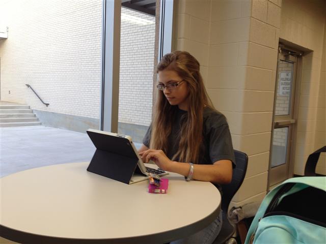 Freshman Emma Bredenkamp works with her iPad in the freshmen center. She uses the study areas to complete assignments.