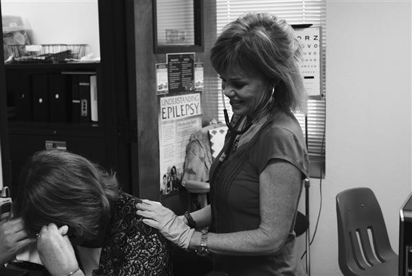 Nurse Margot Boyd tends to a patient. She wears protective gloves to avoid the spread of germs. 