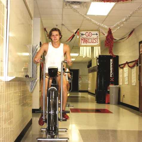 Senior Andrew Duffy rides a stationary bike in the cross country hallway every morning for an hour to keep in shape. One of Duffy's vertebrae was cracked in August during a rock climbing accident, 
