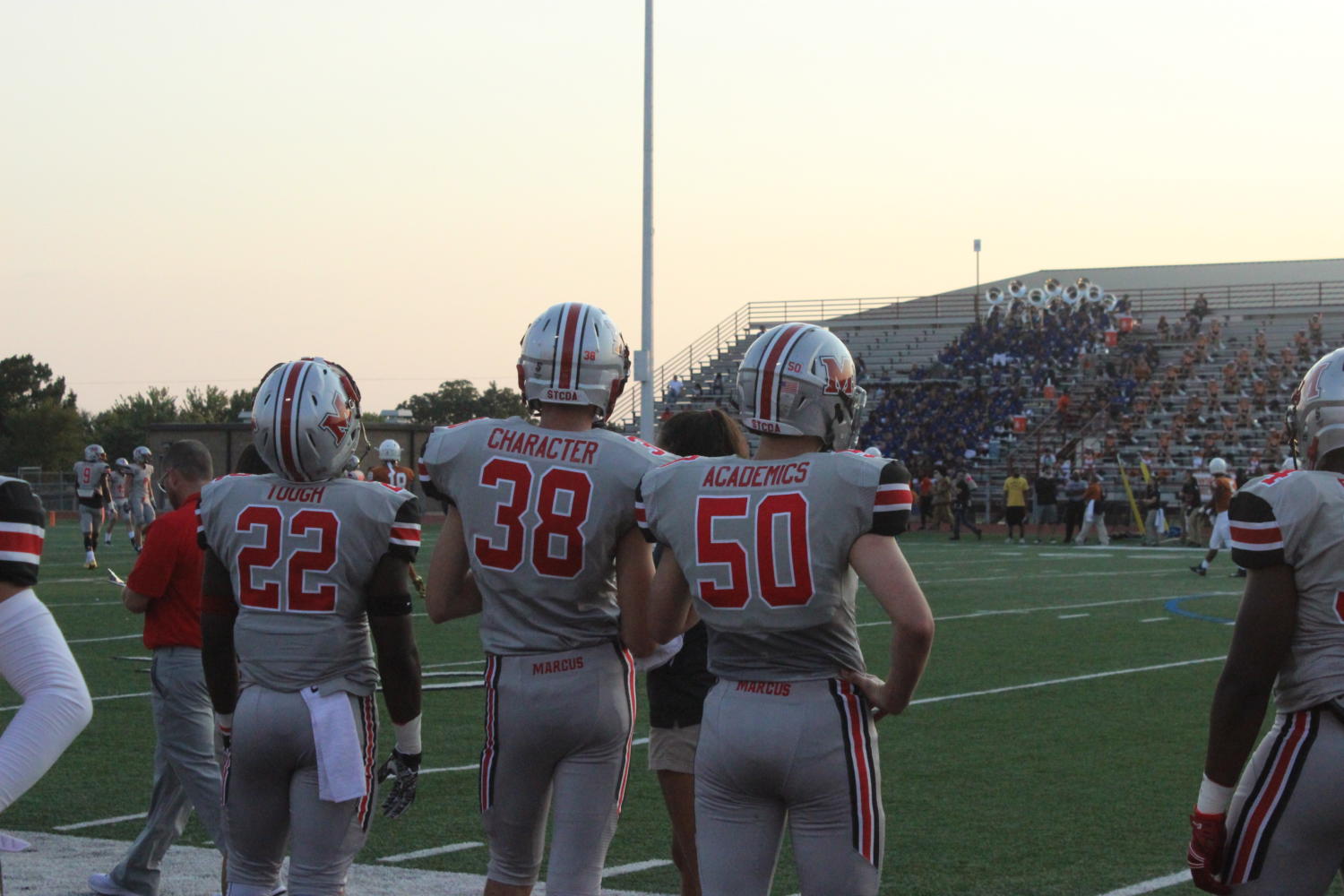 Players stand on the sideline wearing three out of five of Marcus footballs core values installed by new head coach Kevin Atkinson. 