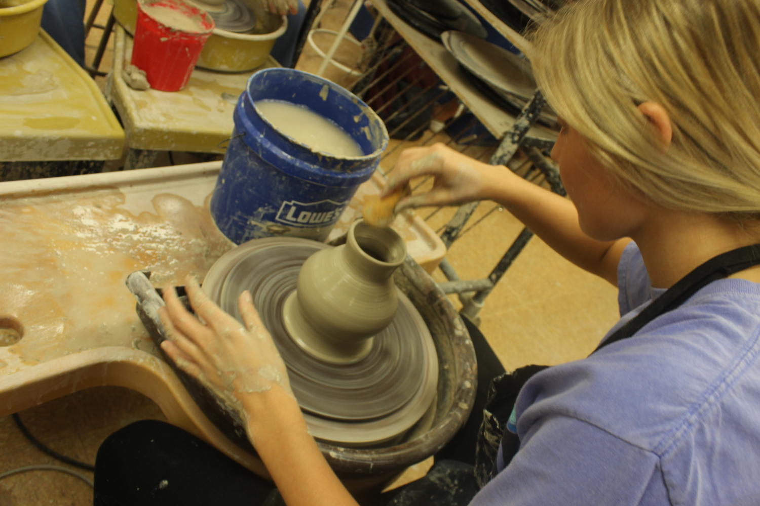 Senior Olivia Gorham utilizes the pottery wheel to form her clay vase.