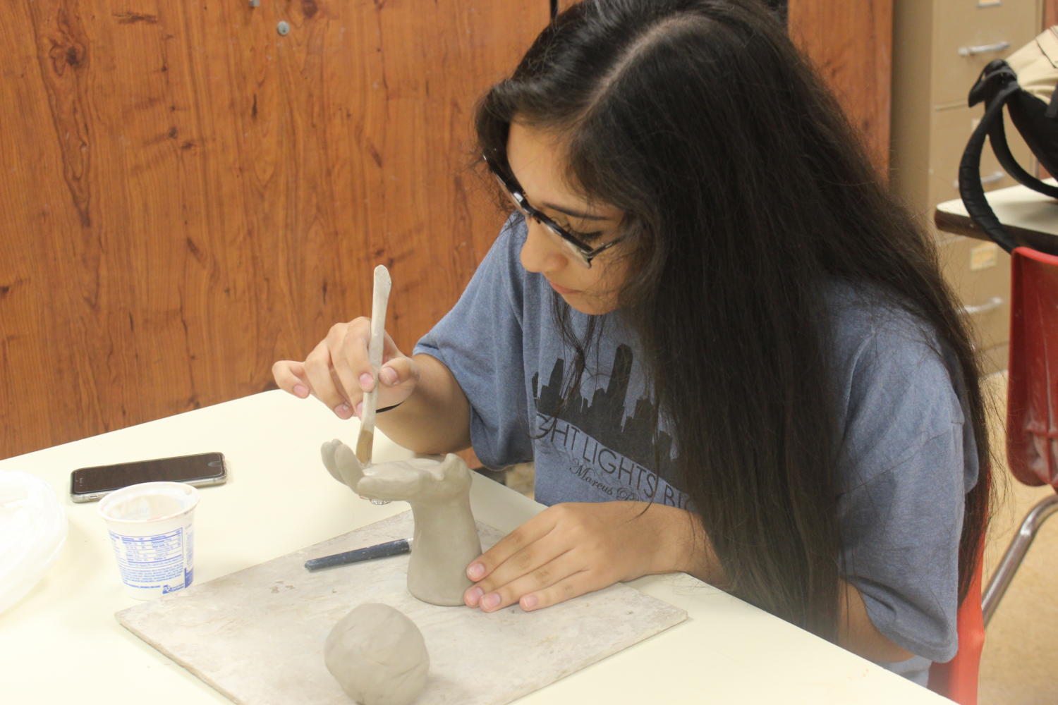 Senior Sophia Gomez sculpts a clay hand.