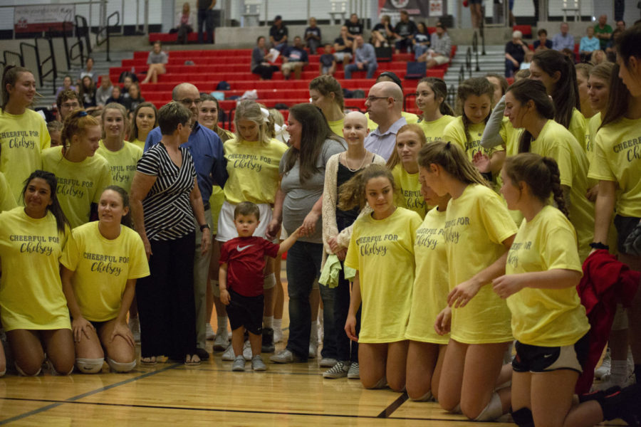 Chelsey Reichenberger stands on the court before the volleyball game waiting to receive her award. Her shy side came out as everyone in the stands had their eyes on her. She said all the attention made her feel nervous.