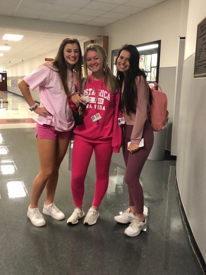 Juniors Alyssa Brown, Brooke Childers and Alex Lengyel show their school pride by participating in Pink Out day on Oct. 11 before the game against Hebron.