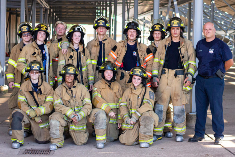The firefighting program gathered for a group photo after practicing forcible entry, which included multiple ways to pry open an almost 300 pound door jammed with pieces of wood.