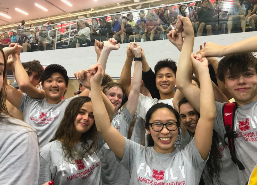 The swim team holds pinkies as they wait for the shootout to begin. At the beginning of big races, the athletes will join together in anticipation and support of their teammates.
