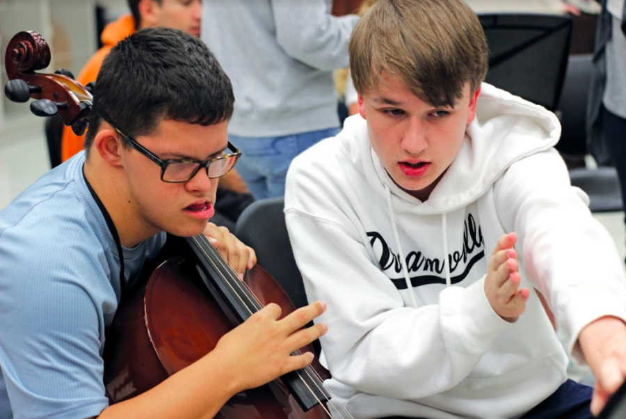 Sophomores Landon Faulkner and Charles Payton read sheet music together. Peer mentors take a leadership role teaching them the fundementals of this skill. 
