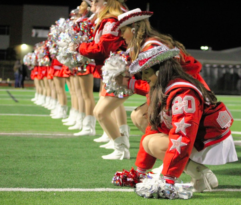 Senior Marquette officer Bella Fortino crouches down during their performance. The rest of the Marquettes follow her lead and get in the same position, moving down the line. 