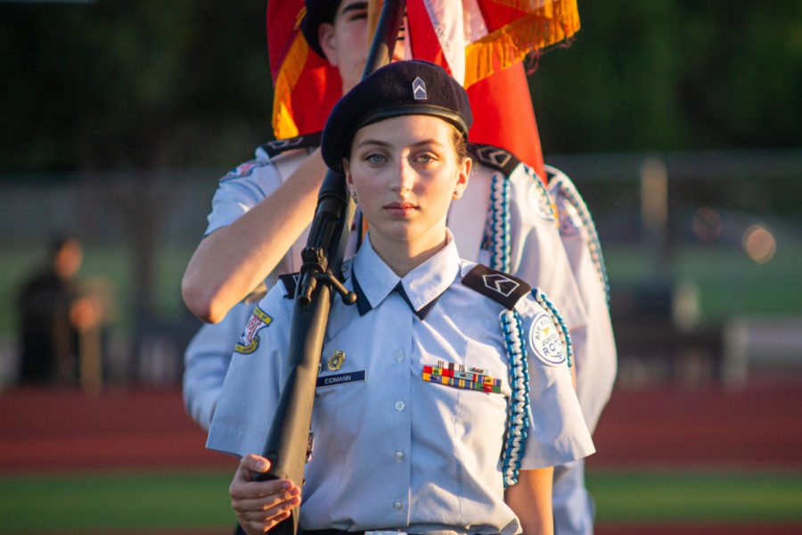 Senior Emma Eidmann presents the colors alongside other AFJROTC students, representing the Marauders prior to the Homecoming football game.