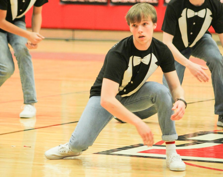 Senior Dylan Duckworth crouches down in time with the music as the other Mr. Marcus contestants do the same. Partway through the routine, the senior boys broke into several smaller groups to perform different dances.