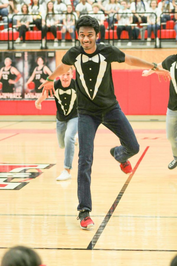 Senior Siddarth Jayakumar jumps towards the stands where students are sitting. The Mr. Marcus contestants performed a short dance routine to promote the competition, which will be held tomorrow night. 