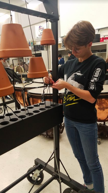 Senior Renee Gomez works on retying her flower pots to an empty chimes frame for her percussion ensemble Phylogeny.