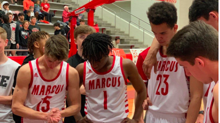 The boys varsity basketball team huddles around head coach Shane Rogers as he discusses the game. The Marauders lost to the Flower Mound Jaguars 66-51.