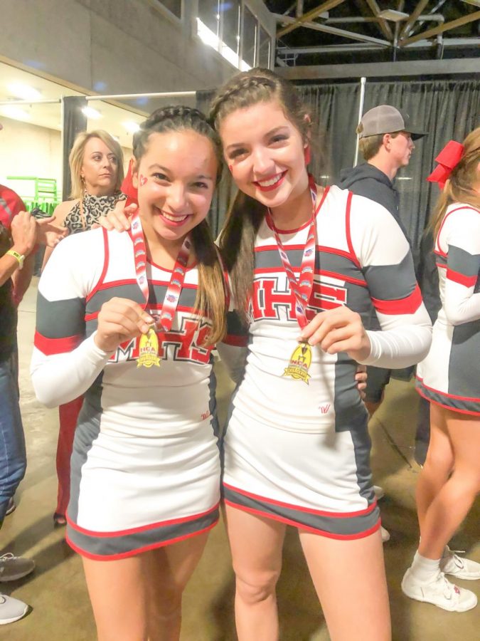 Juniors Yasmeen Siddiqi and Natalie de Berjeois pose together with their medals. The cheerleading team performed to a remix of “I Love Rock and Roll” for part of their routine where they changed the words “rock and roll” to “Marcus.”