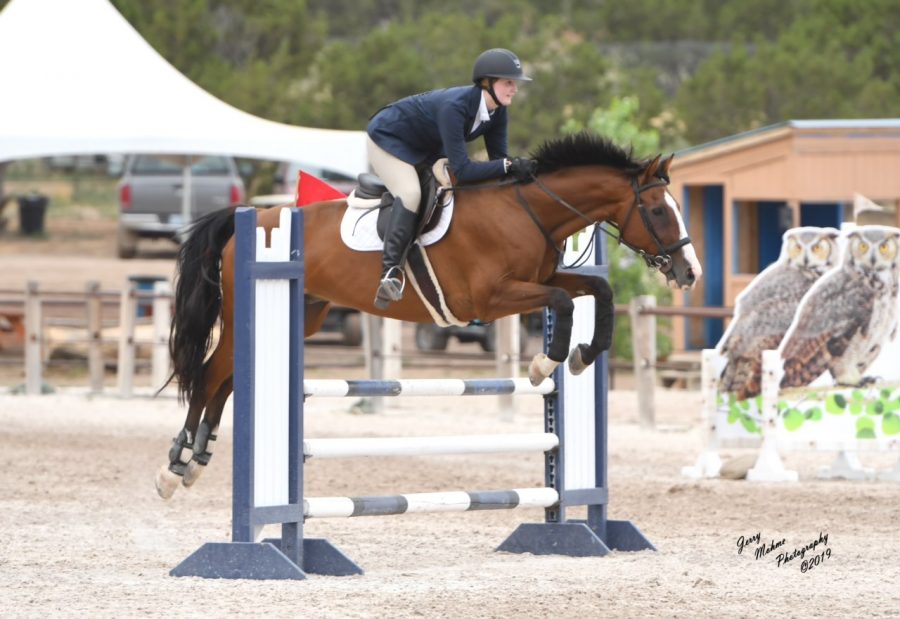 Senior Ashleigh Jooste guides her horse, Max, over a jump at a 2019 competition. She plans to study to become a large animal vet in the future.