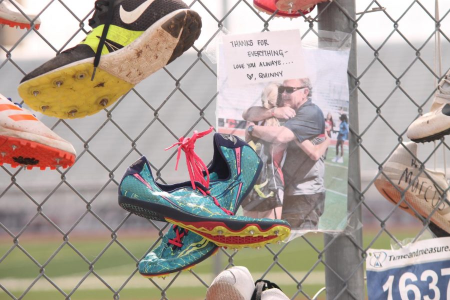 Athletes honor Head Cross Country, Track and Field Coach Steve Telaneus by hanging notes, shoes and shirts on the gate outside of the track.