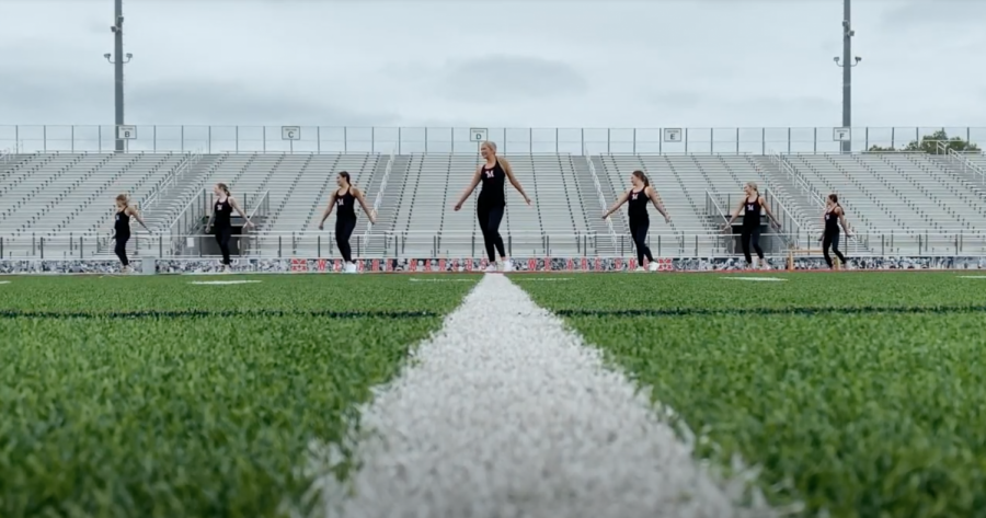 A screenshot from the virtual pep rally shows the Marquettes performing a dance routine on the football field.