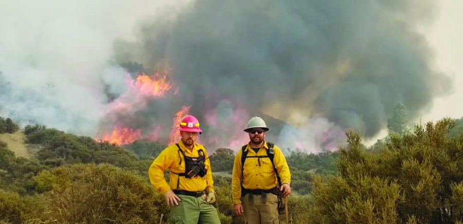 Flower Mound Fire Department Captain Wade Woody and Engineer Brody Eakin wear protective gear in front of the August Complex wildfire. They stayed in California for about two weeks.