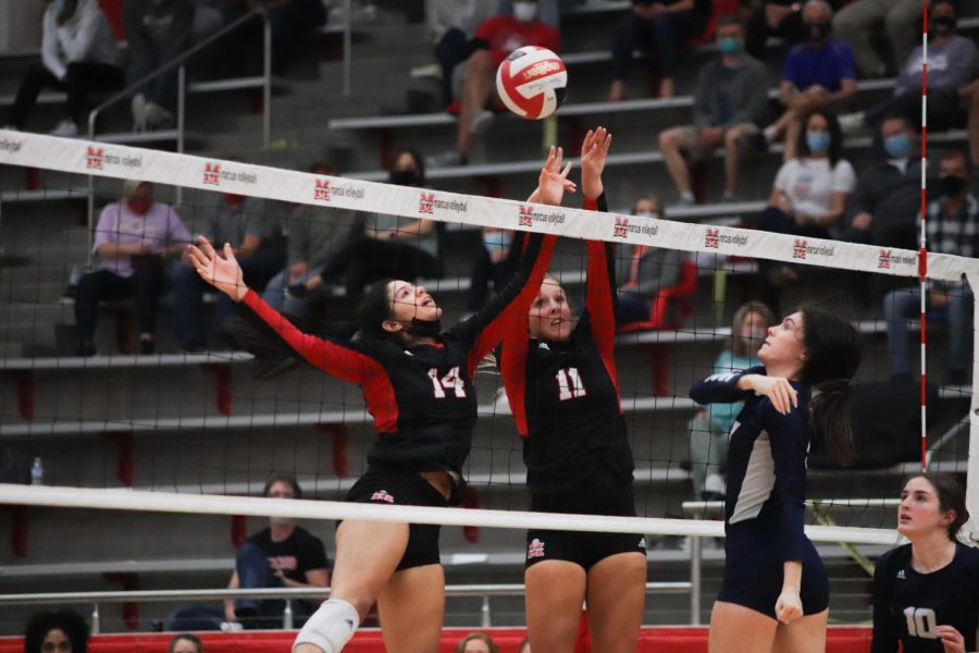 Senior Jazmyn Edmond and junior Maggie Boyd jump to block the ball. 