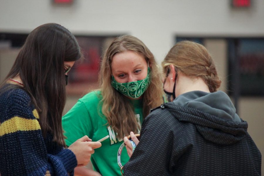 Senior Kaylyn King talks with her friends after signing to swim at the University of North Texas. Athletes signed to play at their respective colleges in the Marauder Gym on Nov. 11.