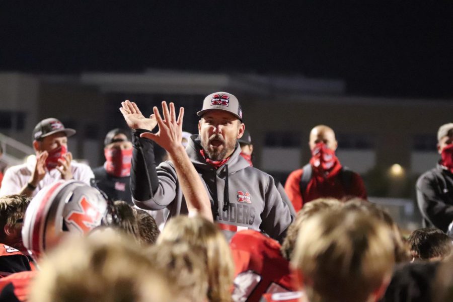 Head Coach Kevin Atkinson celebrates with the team after they secure the win against Plano.