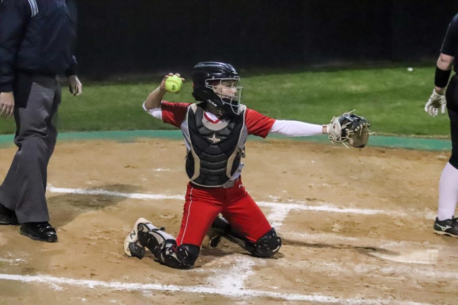 Junior Alexa Hanish throws the ball back to the pitchers mound after catching it.