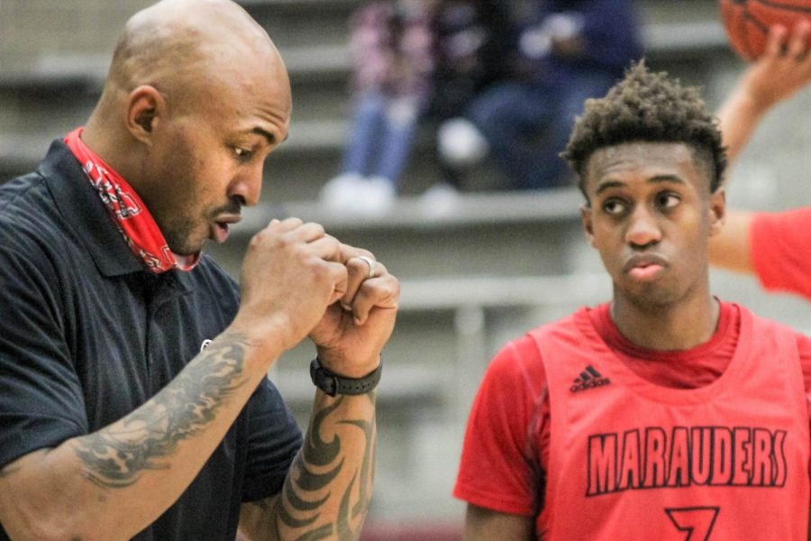 Assistant Basketball Coach James Singleton instructs junior Christian Weddington during the game on Feb. 2. 