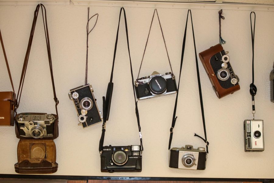 Photography teacher Kathy Toews keeps cameras on a wall in her classroom. They are all different ages and models.