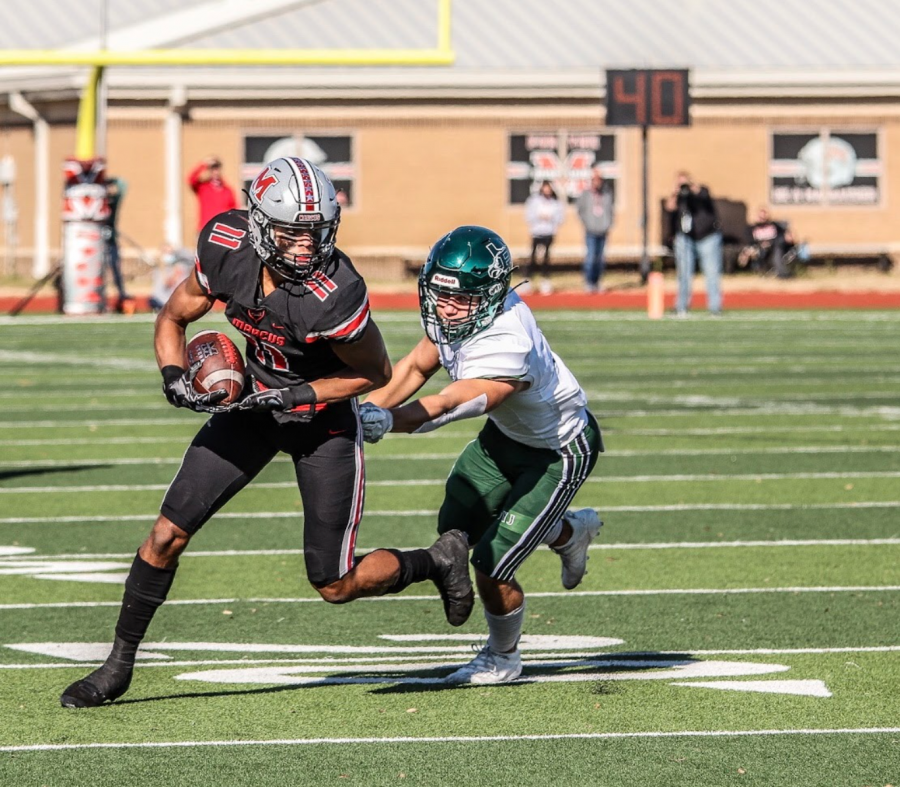 Junior wide receiver and defensive back Dallas Dudley runs through an attempted tackle by a Prosper player.