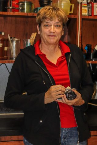Photography teacher Kathy Toews poses with her first camera, an Olympus OM-1. Toews has taught for 25 years and shares her and her father’s love for photography with students.