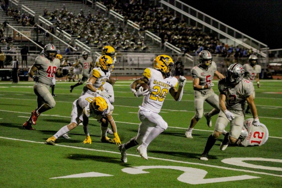 A McKinney player clutches the ball before getting tackled by Marcus Cade Venuk.
