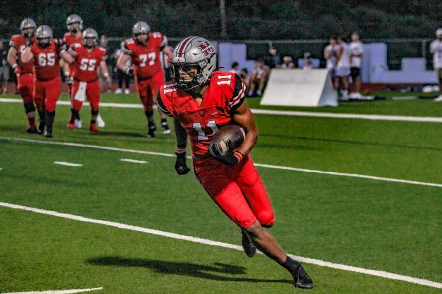 Senior receiver Dallas Dudley carries the ball across the field during the Mound Showdown game on Sept. 24.