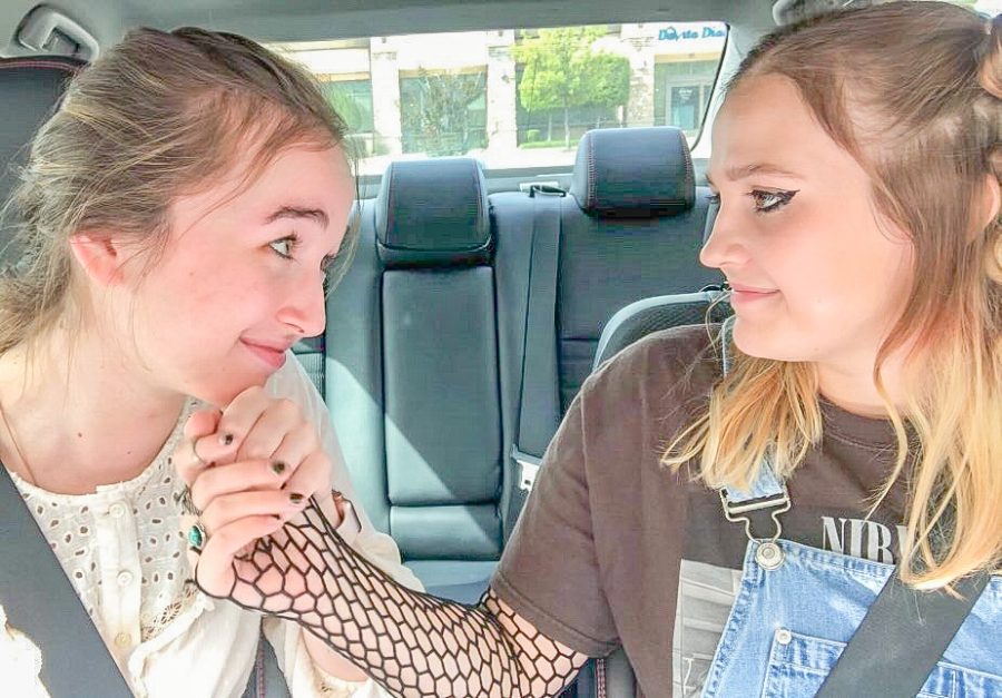 Characters Devin and Olive, played by Abigail Frantz and Jordan Thompson, sit in the car, before going to the mall. They sing along to “Passport” by Ross Newhouse. 