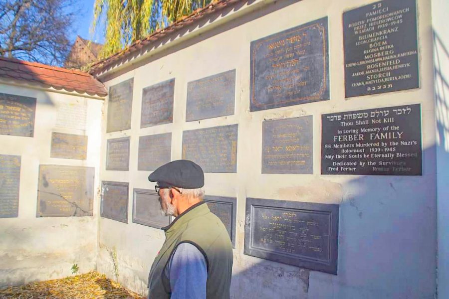 Rabbi Geoffrey Dennis visits gravestones cemented into a wall in Kazimierz Dolny, Poland. A survivor created this memorial to commemorate graves destroyed by Nazis.