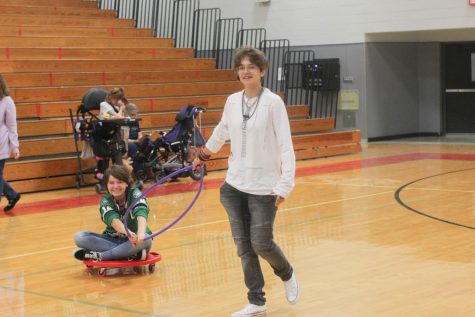 Sophomore Alex Alvarez pulls sophomore Sheila Povar on a scooter during free time. Leaders and partners spend the class period playing games together. 