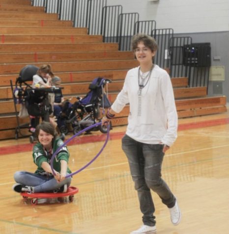 Sophomore Alex Alvarez pulls sophomore Sheila Povar on a scooter during freetime. Leaders and partners spend the class period playing games together.