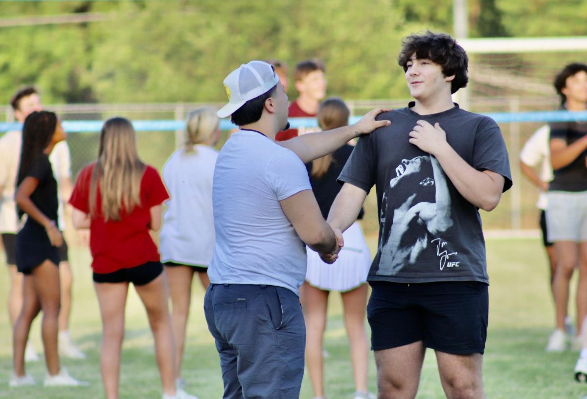 Reyes Molina and Maddox Neese shake hands at Senior Sunset on April 17, 2025.