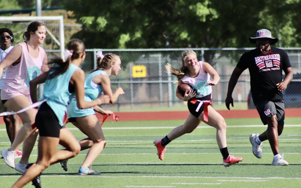Brooke Dunbar, 11, heads towards the sideline to avoid senior defenders during the annual Powder Puff football game on April 17, 2025.